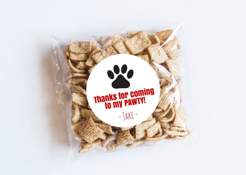 Op de afbeelding: Een witte ronde sticker met een zwarte pootprint en de tekst "Bedankt voor het komen naar mijn PAWTY! - JAKE -" in rood.