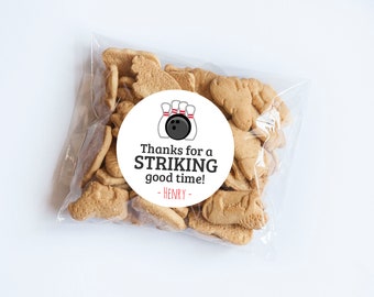 May include: A white circle sticker with a black and white bowling ball and pins graphic. The text on the sticker reads "Thanks for a STRIKING good time! - HENRY - "
