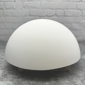 May include: A white ceramic dome, perfect for crafting and DIY projects. The dome is smooth and has a rounded shape.