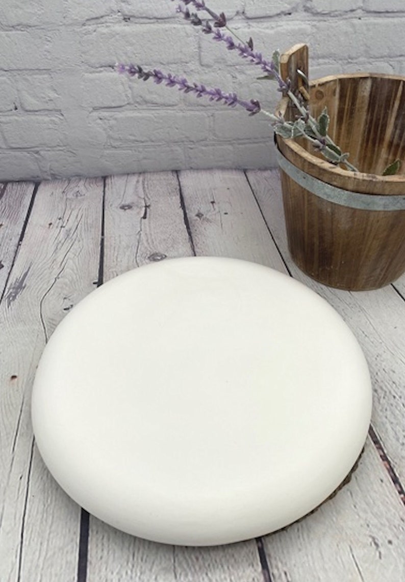 May include: A white round cake dummy, perfect for practicing cake decorating techniques or displaying finished cakes.