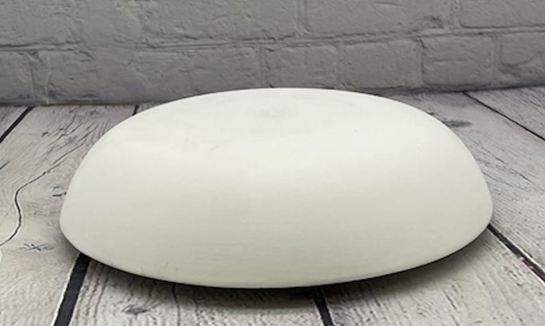 May include: A white ceramic dome shaped bowl, perfect for displaying small items or creating a unique centerpiece.