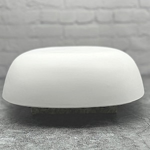 May include: A white ceramic bowl with a smooth, rounded surface. The bowl is empty and appears to be made of a thick, durable material.