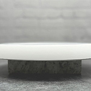 May include: A white ceramic pedestal with a round top and a textured base.