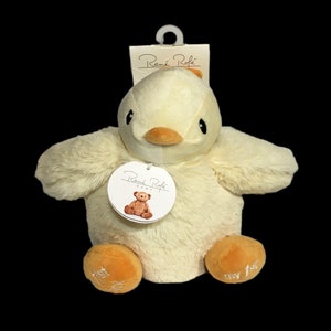 May include: A soft, plush yellow chick toy with a small orange beak and black eyes. The toy has a white tag with the text "Reue Rofe Baby" and a brown teddy bear illustration. The chick's feet are orange and have the text "my 1st" embroidered on them.