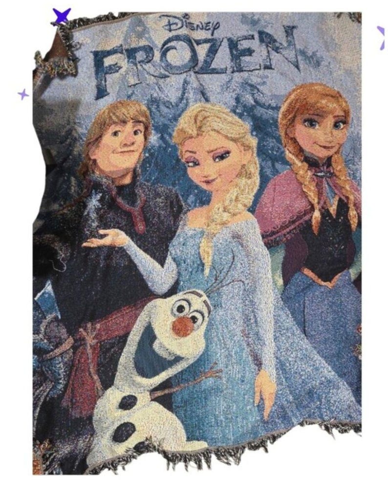 May include: A woven tapestry throw blanket featuring the Disney Frozen logo at the top. The design depicts Kristoff, Elsa, Anna, and Olaf in a snowy, blue-toned landscape. The blanket has a textured, thread-woven appearance with fringed edges.
