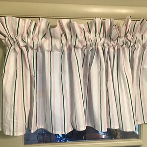 May include: White valance with pink and green stripes. The valance is gathered and has a ruffled edge.