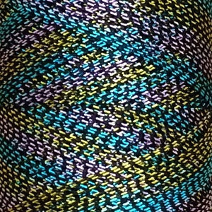 May include: A close-up of a fabric with a repeating pattern of diagonal lines in shades of black, yellow, blue, and purple.