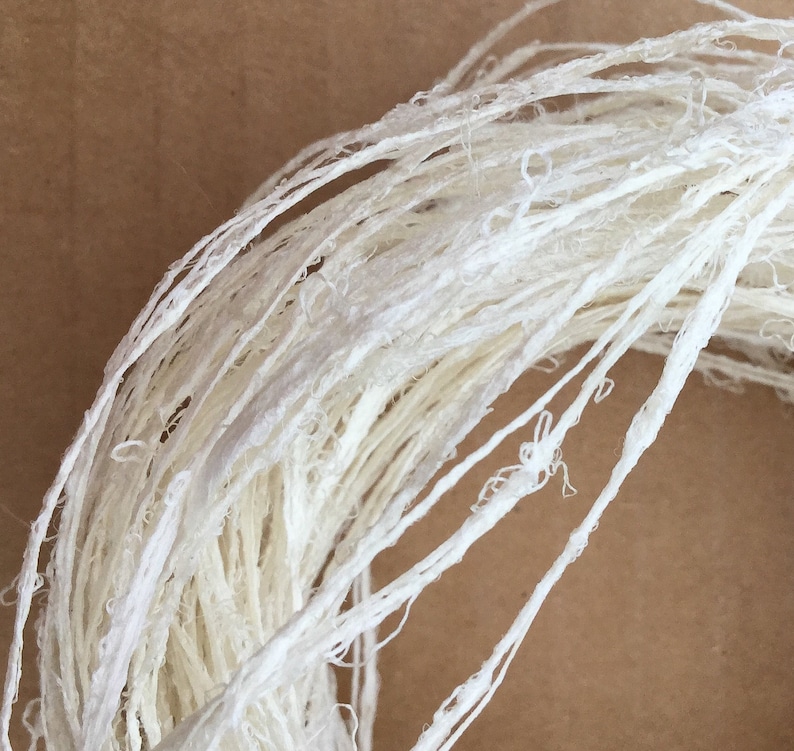 May include: A close-up of a white, natural fiber rope, made from paper, perfect for crafting and decorating.