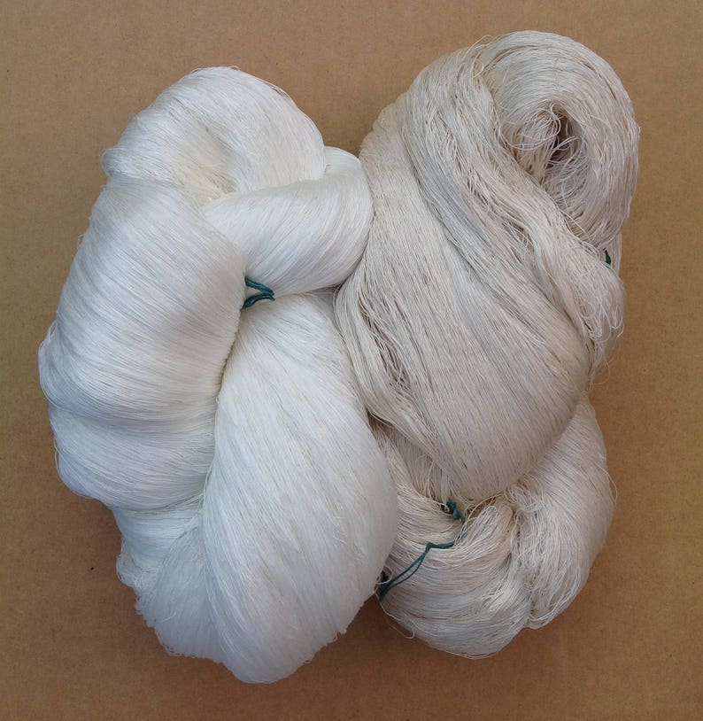 May include: Two bundles of white yarn, tied together with green string. The yarn is soft and fluffy, and it is perfect for knitting or crocheting.
