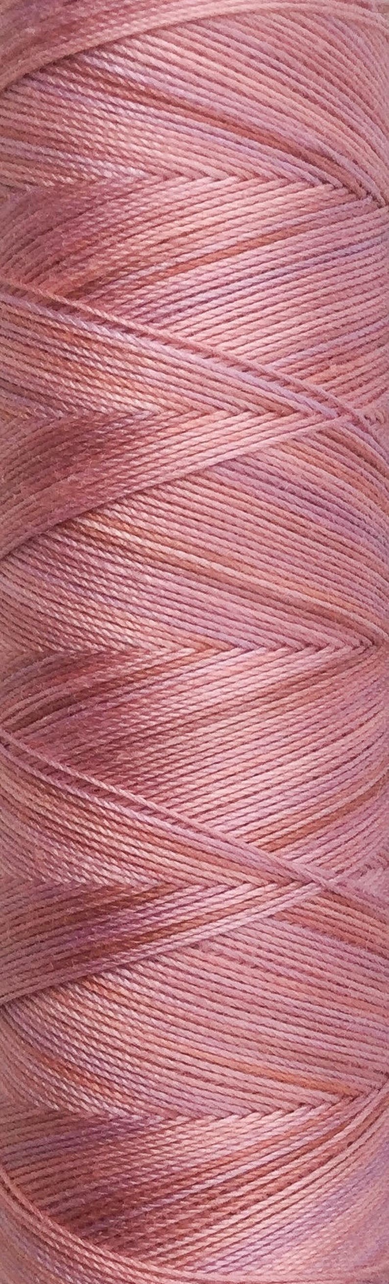 May include: A spool of pink embroidery floss. The floss is wound tightly and has a subtle ombre effect.
