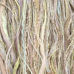 May include: Close-up of a textured textile with a mix of pastel colors. The strands are interwoven, featuring shades of pink, yellow, and green, with metallic silver accents. The overall effect is soft and delicate, suggesting a craft or decorative item.