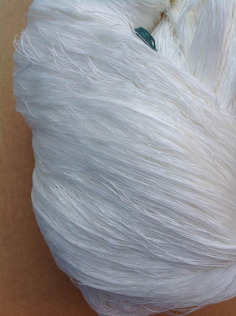 May include: A close-up of a bundle of white yarn. The yarn is soft and fluffy, and it is perfect for knitting or crocheting.