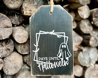 May include: Black wooden sign with a white ghost and bats, and the text "Days Until Halloween".