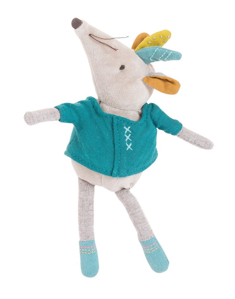 May include: A gray plush mouse wearing a teal blue shirt with white stitching and a yellow, green, and blue feather crown. The mouse has gray legs and blue socks.