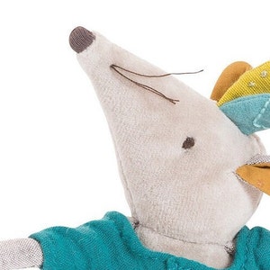 May include: A plush gray mouse toy with a blue and yellow patterned head. The mouse is wearing a teal blue shirt.