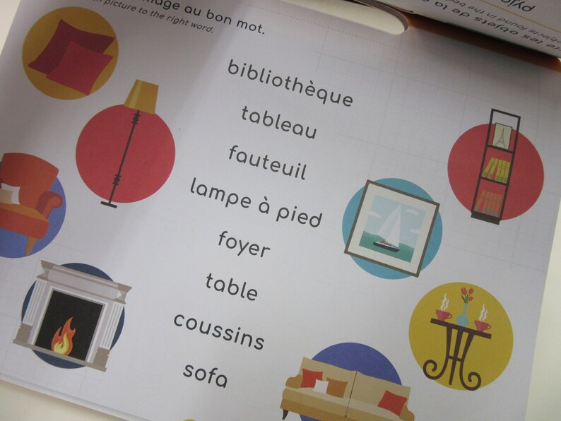 K&ouml;nnte beinhalten: Eine bunte Illustration verschiedener Einrichtungsgegenst&auml;nde, darunter ein Sofa, ein Kamin, eine Lampe, ein B&uuml;cherregal, ein Tisch und ein Bilderrahmen. Die Illustration ist mit franz&ouml;sischen W&ouml;rtern f&uuml;r jeden Gegenstand versehen.