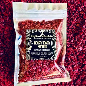 May include: A clear plastic bag filled with red crystal potpourri. The label reads "Roasty Toasty Reindeer" and "Festive Fireplace". The bag contains 6 oz of sizzling room salts.