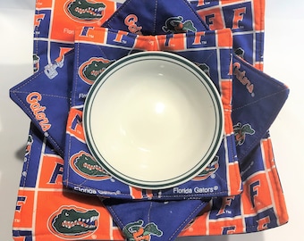 May include: Set of four blue and orange fabric bowl cozies with an alligator logo and the text "Florida Gators".