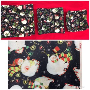 May include: Three black fabric cozies with a snowman pattern. The cozies mare different sizes and have a white background with red, green, and black accents. The fabric is quilted,has a soft texture. and is safe to use in the microwave