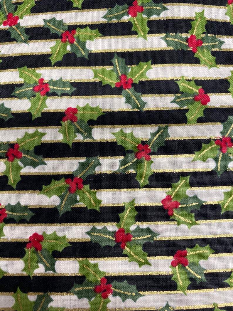 May include: Black and white striped fabric with a repeating pattern of green holly leaves and red berries. The stripes are accented with gold thread.