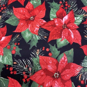 May include: Red poinsettia flowers with green leaves and red berries on a black background. This fabric features a repeating pattern of holiday floral elements.