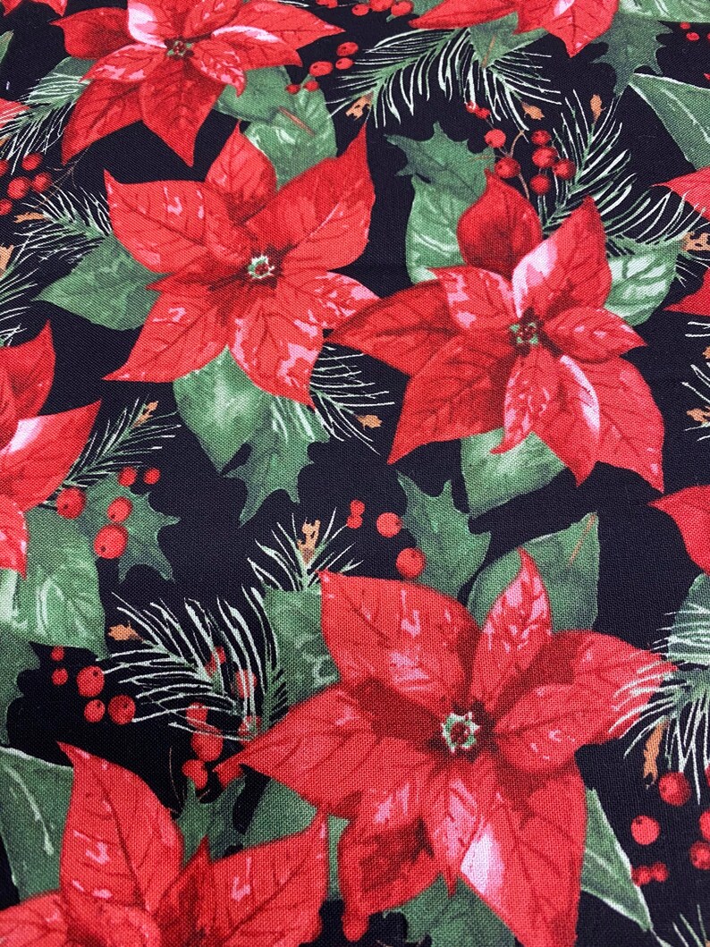 May include: Red poinsettia flowers with green leaves and red berries on a black background. This fabric features a repeating pattern of holiday floral elements.