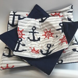 May include: Set of three navy blue and white striped pot holders with anchors and red steering wheels. The pot holders are quilted and have a layer of navy blue fabric on the back.