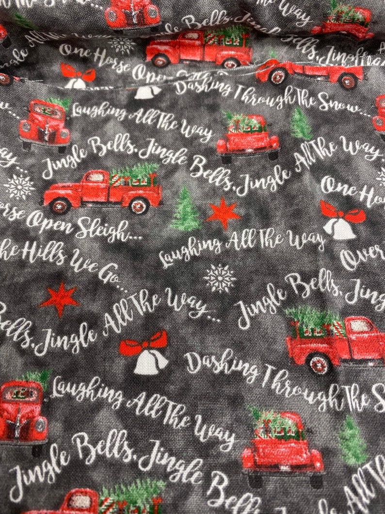 May include: Red pickup trucks with Christmas trees in the back drive through a snowy landscape. The trucks are surrounded by the words "Jingle Bells, Jingle All The Way" and "Dashing Through The Snow".
