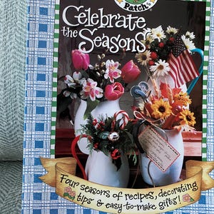 May include: A book cover with a blue and white checkered background. The title is "Celebrate the Seasons" with a goose and berry logo. The book features four seasons of recipes, decorating tips, and easy-to-make gifts.