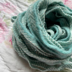 May include: A teal and white striped yarn skein, rolled into a ball shape.