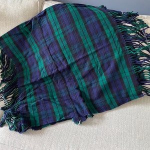 May include: A green and blue plaid throw blanket with fringe on all sides.