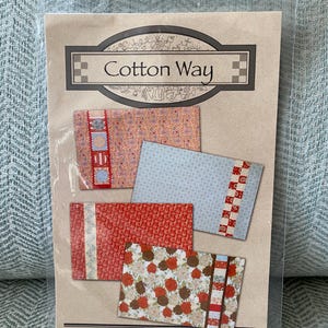 May include: A sewing pattern for patchwork pillowcases from Cotton Way, featuring four different designs with red, blue, and brown fabrics. The pattern is labeled "Patchwork Pillowcases #917".