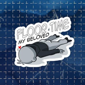 Pode incluir: Um autocolante com uma ilustração de desenho animado de uma figura deitada no chão, com o texto "FLOOR TIME MY BELOVED". A figura está vestida com um casaco e calças. Um pequeno coração vermelho está ao lado da figura.