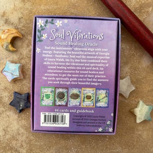 May include: A Soul Vibrations Sound Healing Oracle card deck with a purple box featuring floral accents and the text "Soul Vibrations." The deck includes 44 cards and a guidebook. Decorative star-shaped crystals surround the box.