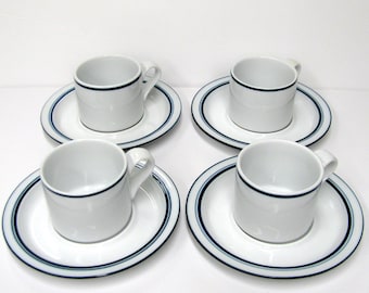 May include: Set of four white porcelain coffee cups and saucers with a blue and black trim.