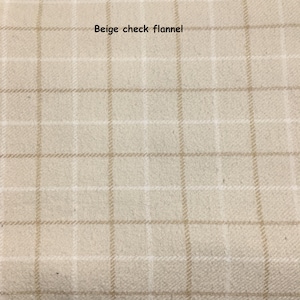 May include: Beige check flannel fabric with a grid pattern. The fabric has a soft, textured appearance. The text "Beige check flannel" is displayed in the upper center of the image.