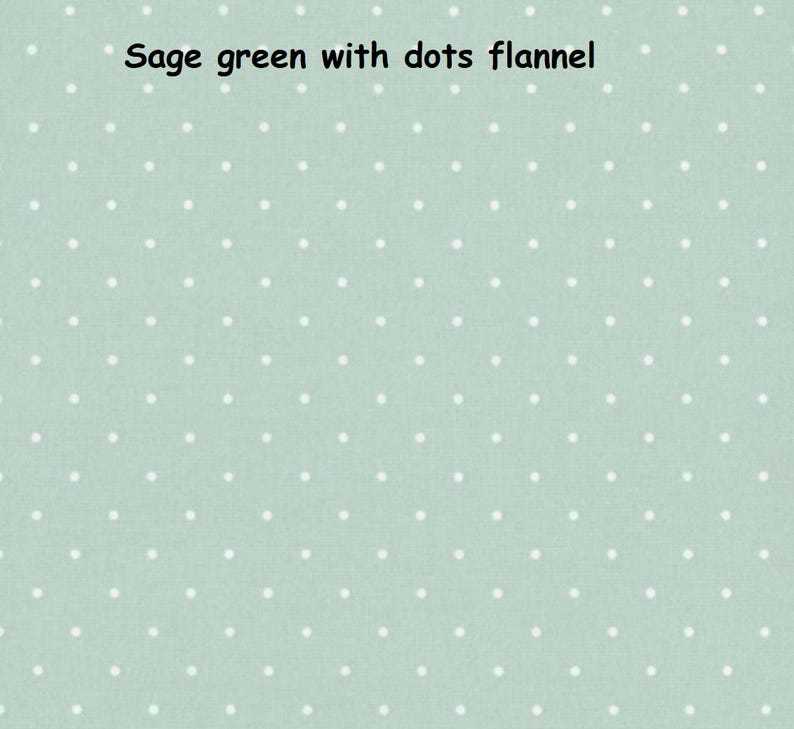 May include: A sage green flannel fabric featuring a repeating pattern of small white polka dots. The text "Sage green with dots flannel" is printed in black at the top centre of the image, describing the textile pattern and material type.