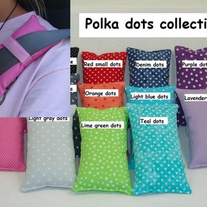 May include: A collection of ten polka dot fabric pillows in various colors, including red, orange, light blue, teal, lime green, light gray, denim, purple, and lavender. The pillows are arranged in two rows, with the text "Polka dots collection" at the top.