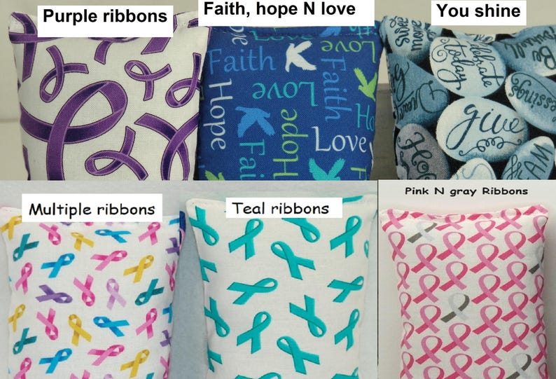 May include: A collection of decorative pillows with various designs. One features purple ribbons, another has the words "Faith, Hope, Love", and a third displays inspirational words on stones. Other pillows show teal, pink, gray, and multiple colored ribbons.