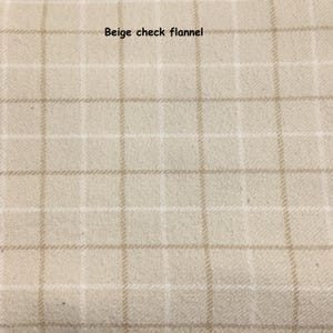Puede incluir: Tejido de franela a cuadros beige. La tela presenta un patr&oacute;n de cuadr&iacute;cula de cuadrados beige claro y blancos. El texto "Beige check flannel" est&aacute; impreso en la parte superior central de la imagen.