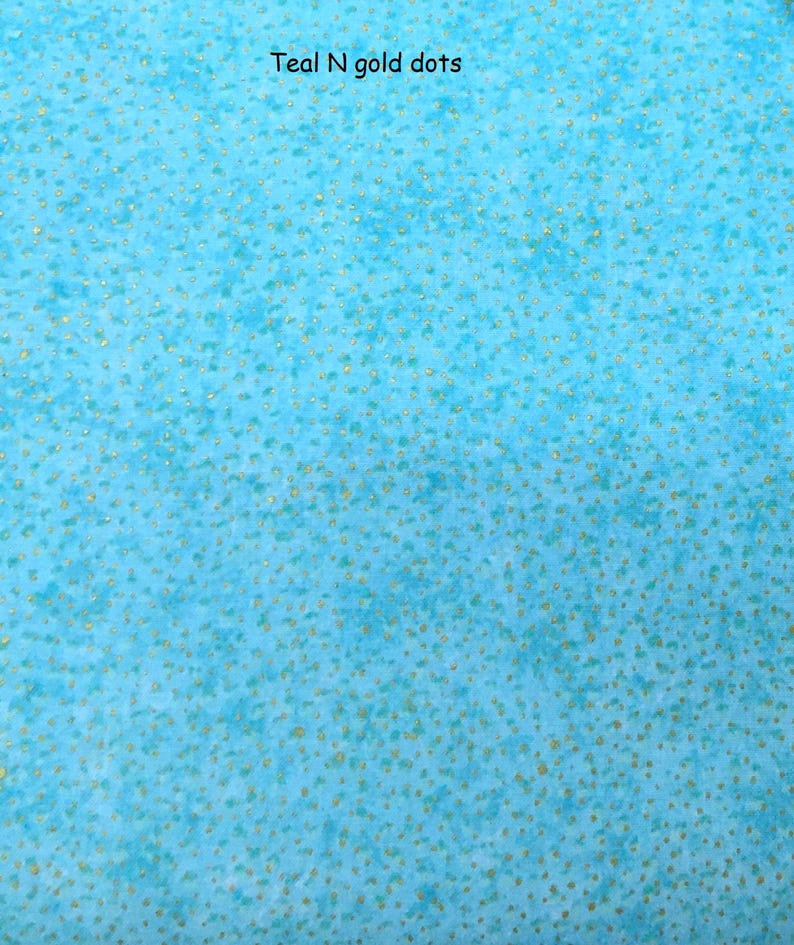 May include: A teal fabric featuring a mottled, watercolour-like texture with a pattern of small, scattered gold dots. The text "Teal N gold dots" is printed in black at the top centre of the image, describing the colour and pattern of the material.