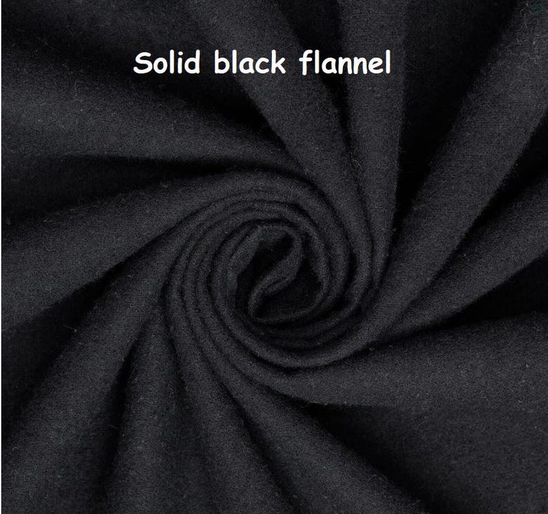 Puede incluir: Primer plano de tela de franela negra lisa. La tela est&aacute; densamente tejida y tiene una superficie suave y ligeramente texturizada. El texto "Solid black flannel" se muestra en letras blancas en la parte superior de la imagen.