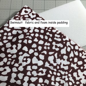 May include: Brown and white patterned swimsuit fabric with foam padding. The fabric has a spotted design. The text "Swimsuit fabric and foam inside padding" is visible.