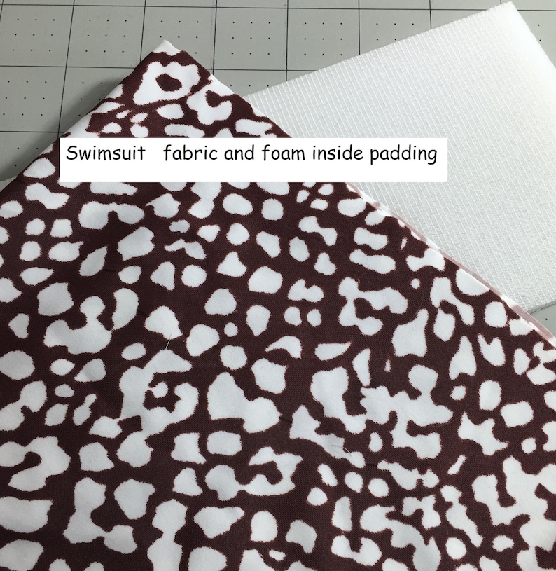 May include: Brown and white patterned swimsuit fabric with foam padding. The fabric has a spotted design. The text "Swimsuit fabric and foam inside padding" is visible.