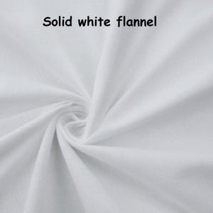 Puede incluir: Primer plano de tela de franela blanca lisa con textura y pliegues visibles. La tela est&aacute; fuertemente arremolinada en el centro, con las palabras "Solid white flannel" en texto negro en la parte superior.