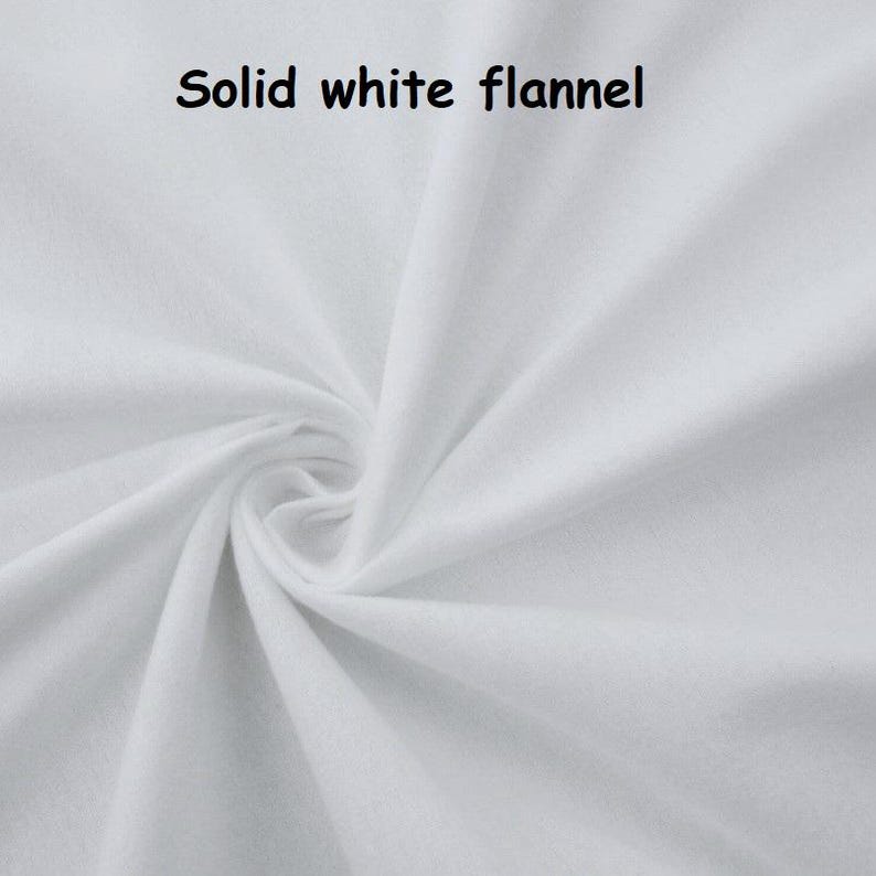 Puede incluir: Primer plano de tela de franela blanca lisa con textura y pliegues visibles. La tela est&aacute; fuertemente arremolinada en el centro, con las palabras "Solid white flannel" en texto negro en la parte superior.