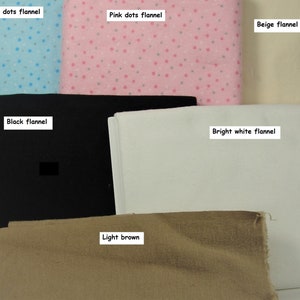 Puede incluir: Una colecci&oacute;n de telas dobladas que incluye franela con puntos azules, franela con puntos rosas, franela beige, franela negra, franela blanco brillante y tela marr&oacute;n claro, cada una etiquetada con su nombre de color y patr&oacute;n.