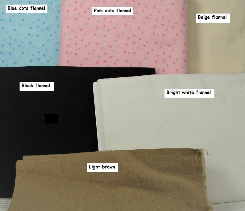 Puede incluir: Una colecci&oacute;n de telas dobladas que incluye franela con puntos azules, franela con puntos rosas, franela beige, franela negra, franela blanco brillante y tela marr&oacute;n claro, cada una etiquetada con su nombre de color y patr&oacute;n.