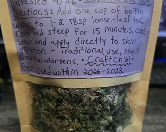 Könnte beinhalten: Ein beigefarbener Papierbeutel mit Sichtfenster, der getrocknete grüne Pflanzenteile enthält. Ein violettes Etikett trägt den handgeschriebenen Text: Climbing Hempvine (Mikandia scandens) Organic, New England ecotype, Harvested 9/26, External use only, Directions: Add one cup of boiling water to 1-2 TBSP loose-leaf tea. Cover and steep for 15 minutes, cool, strain and apply directly to skin irritation - Traditional use, stop if condition worsens. Craft Chibi. Best Used within 2026-2028.