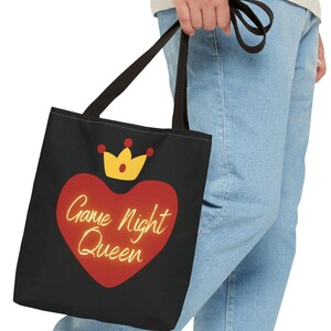 May include: A black tote bag with a red heart and a gold crown. The heart has the text "Game Night Queen" inside.